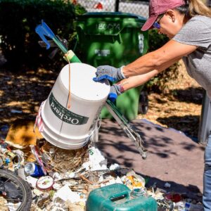 woman dumping bucket of trash